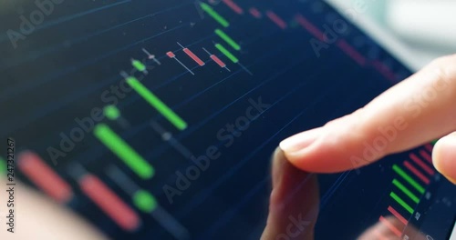 Trader working online with tablet on stock market. Close up 4k screen tablet with numbers and graphs.