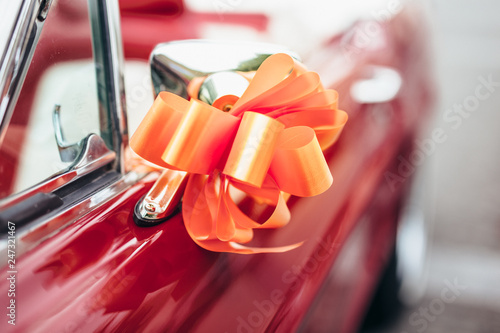 Decoration orange knot on an old red car