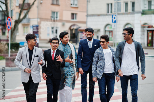 Group of six south asian indian mans in traditional, casual and business wear walking at crosswalk together.