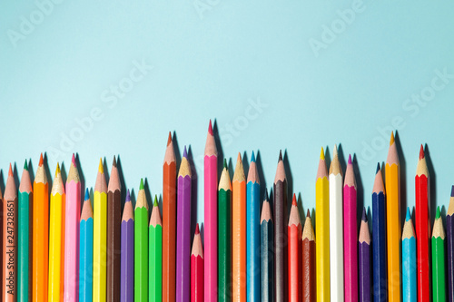 Composition with colored pencils on a bright blue background. top view. space for text.frame