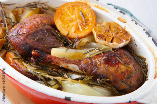 Poultry cooked in a cast iron pan with garlic, orange and aromatic herbs