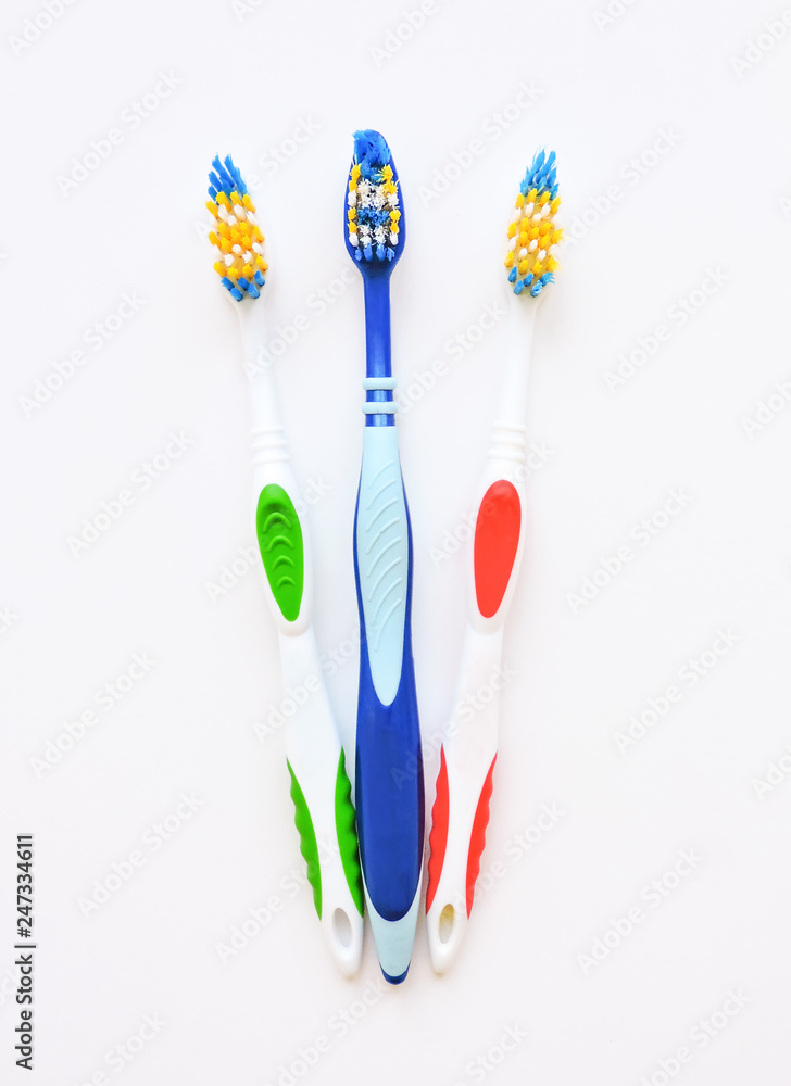 Flat lay composition with manual toothbrushes on white background.Toothbrush and toothpaste.op view, flat lay. Minimal concept, space for text.set of multicolored toothbrushes on white. Flat lay composition with manual toothbrushes on white background.Toothbrush and toothpaste.op view, flat lay. Minimal concept, space for text.set of multicolored toothbrushes on white.