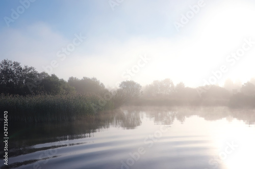 Fog in the lake. Morning nature water white fog.