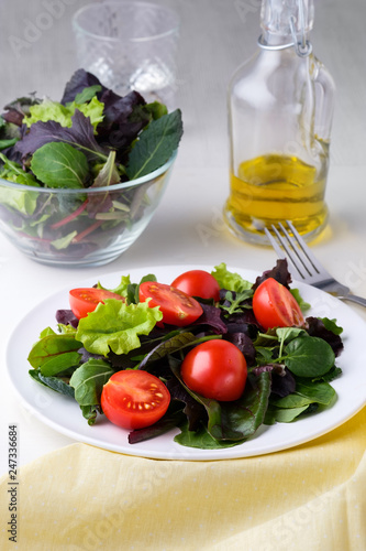fresh colored cherry tomato salad with arugula, Basil, spinach, salad and olive oil dressing. selective focus.