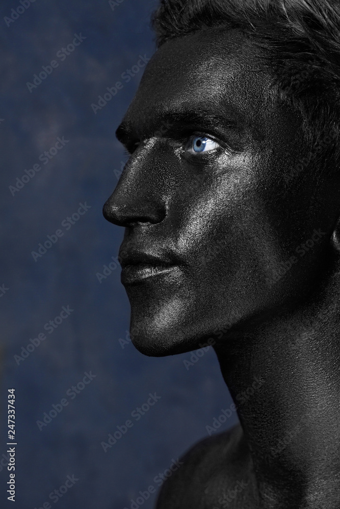 a man in black make-up. portrait in dark paint. Art photography portrait a man in black make-up. portrait in dark paint. Art photography portrait