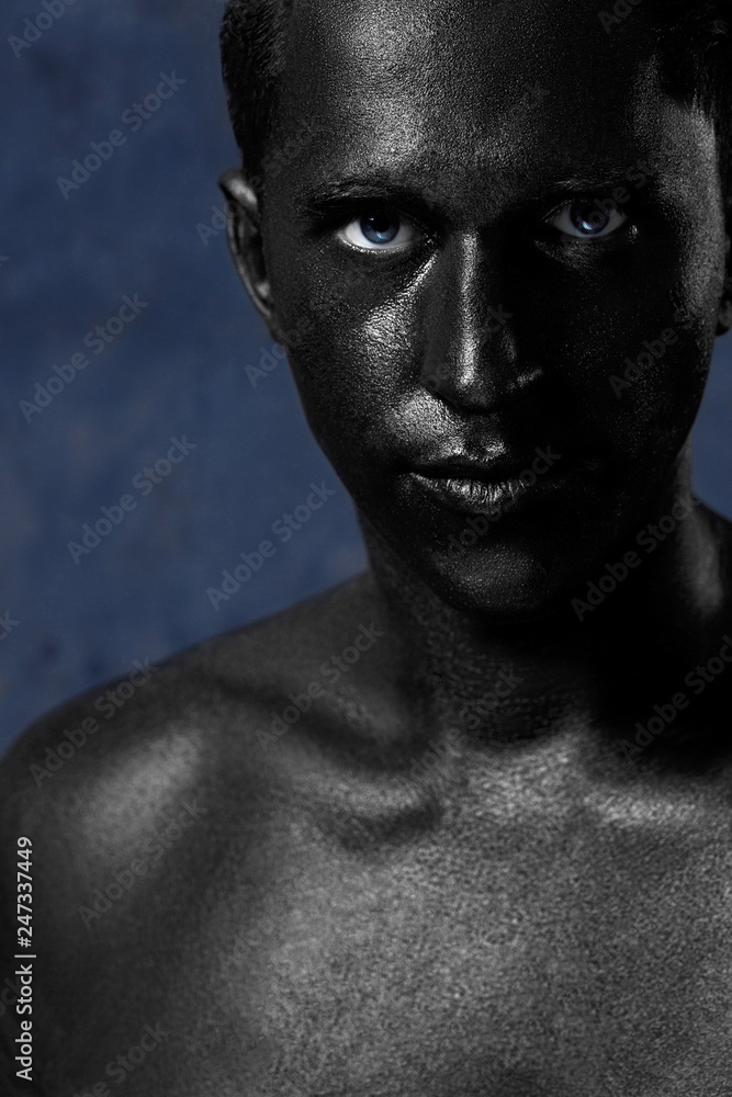 a man in black make-up. portrait in dark paint. Art photography portrait