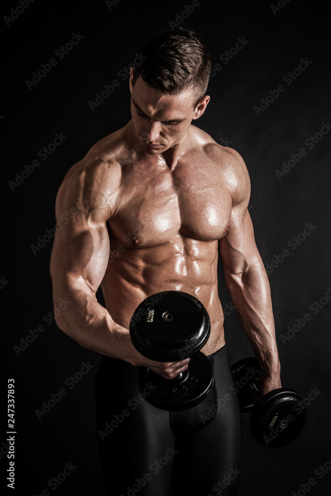 Athletic shirtless young male fitness model with dumbbells Stock Photo