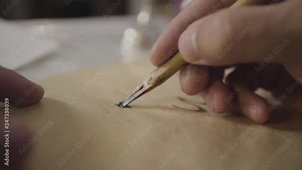 Close up male hand writing Alif Arabic character Close up male hand writing Alif Arabic character