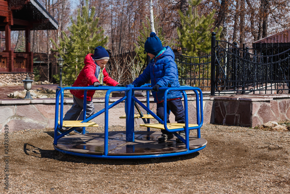 two boys in jackets play in the playground two boys in jackets play in the playground