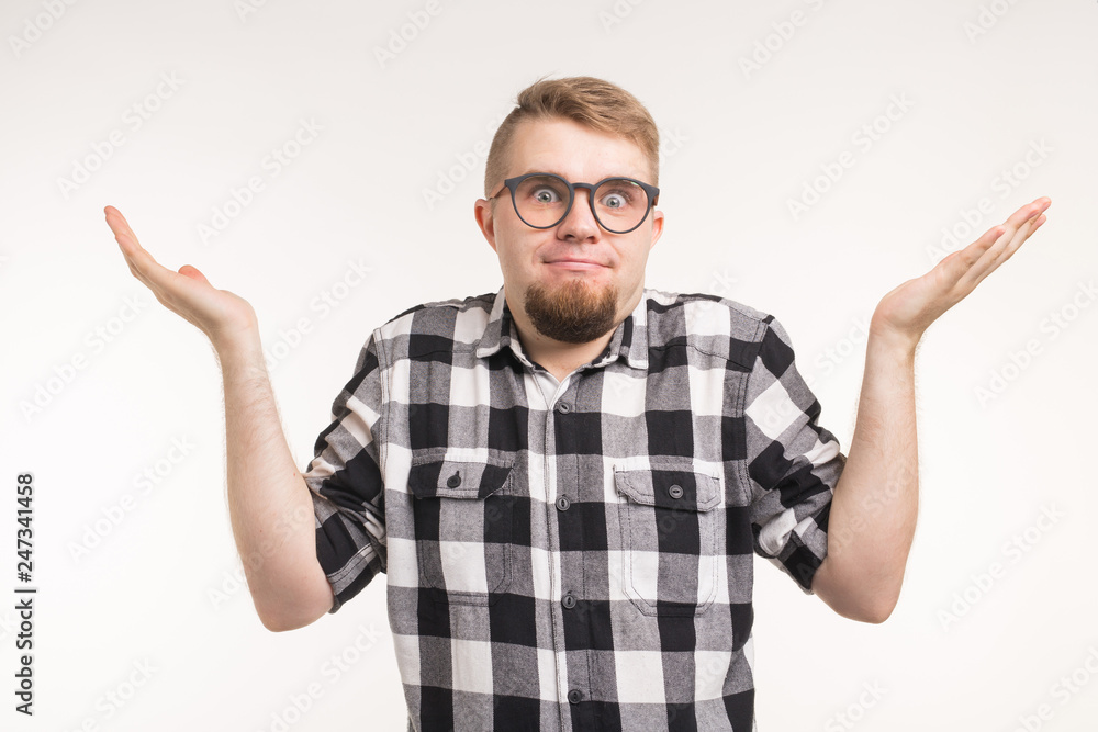 Puzzled student man in plaid shirt over white backgroung Puzzled student man in plaid shirt over white backgroung