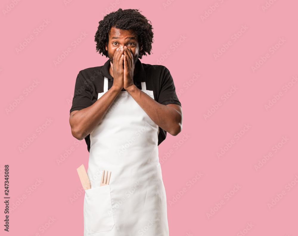 Handsome african american baker very scared and afraid, desperate for something, cries of suffering and open eyes, concept of madness Handsome african american baker very scared and afraid, desperate for something, cries of suffering and open eyes, concept of madness