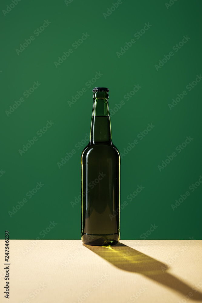 beer bottle with shadow isolated on green, st patrick day concept beer bottle with shadow isolated on green, st patrick day concept