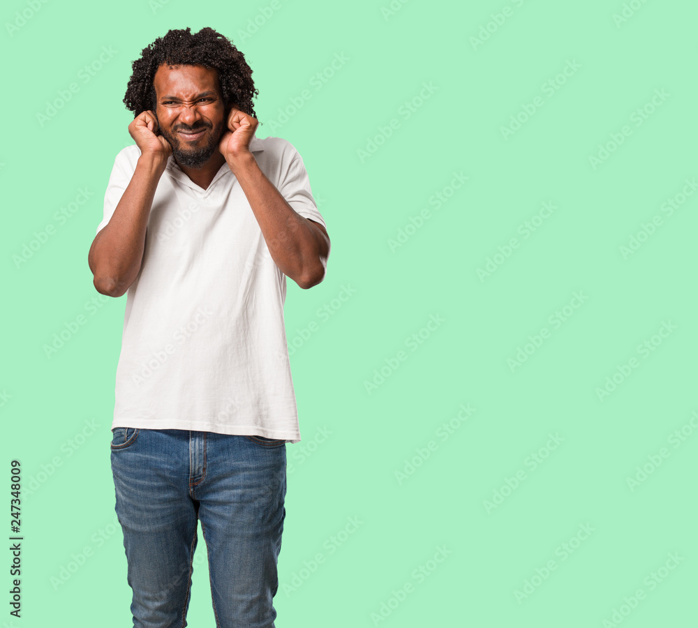 Handsome african american covering ears with hands, angry and tired of hearing some sound Handsome african american covering ears with hands, angry and tired of hearing some sound