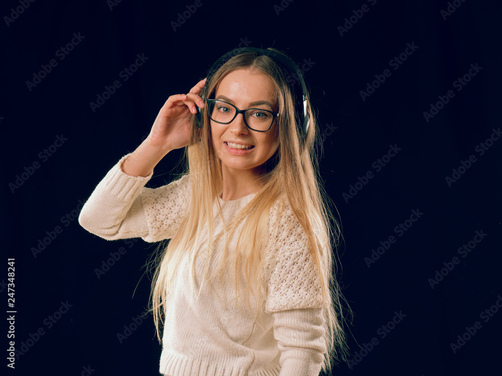 beautiful cheerful girl in headphones on black background. beautiful cheerful girl in headphones on black background.