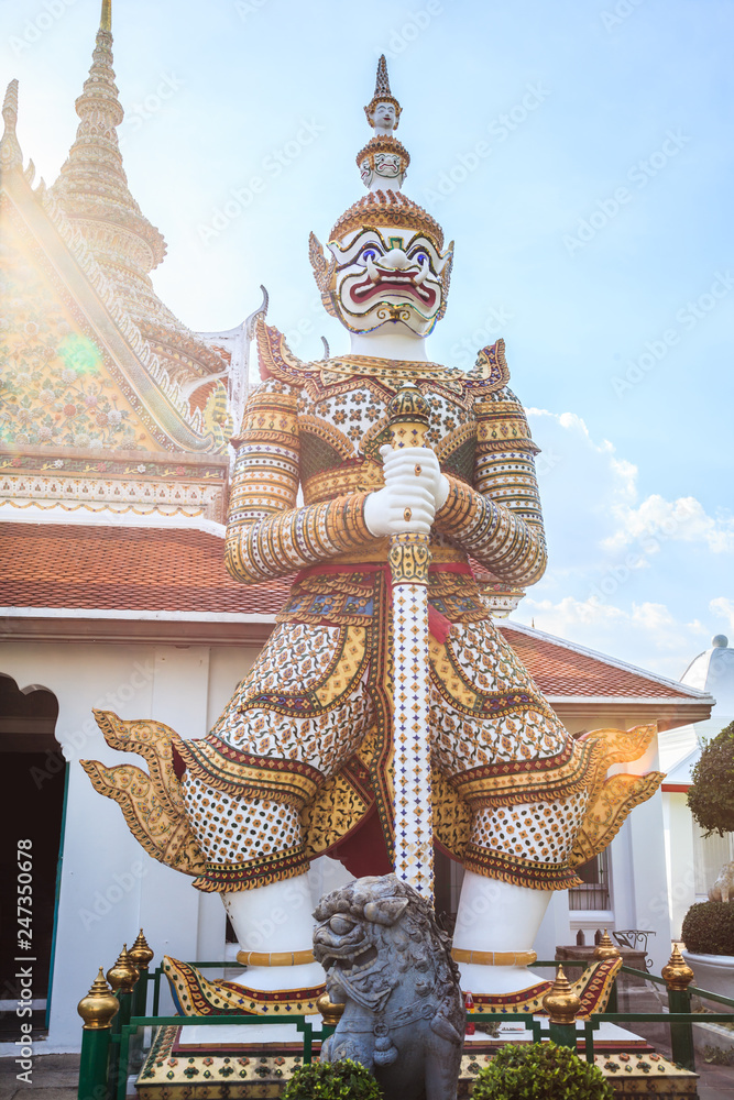 ancient temple guardian in front of Temple of Dawn (Wat Arun Buddhist Temple) is white demon giant statue named Sahatsadecha. Thailand Traditional Tourist Attraction, Thai Travel and Tourism concept