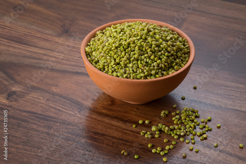 Front  View of Fresh Green Tender Sorghum in a Earthen Bowl on Wooden Background