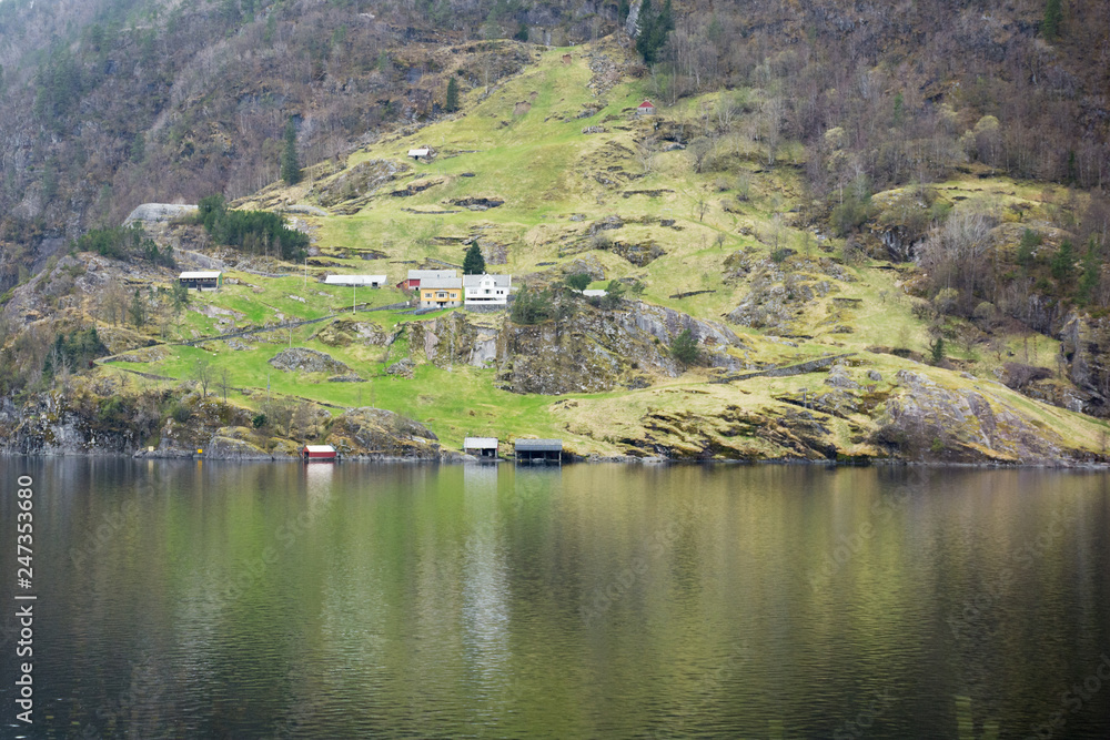 Fototapeta premium view of a small Norwegian village and traditional, wooden, residential buildings on the shore of the fjord. Norway.