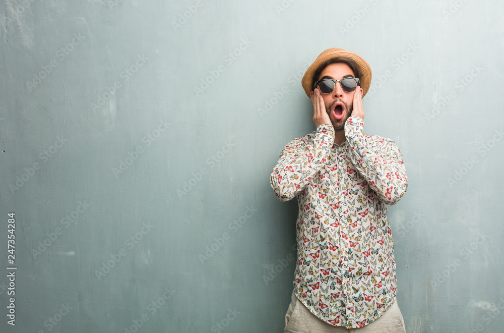 Fototapeta premium Young traveler man wearing a colorful shirt frustrated and desperate, angry and sad with hands on head