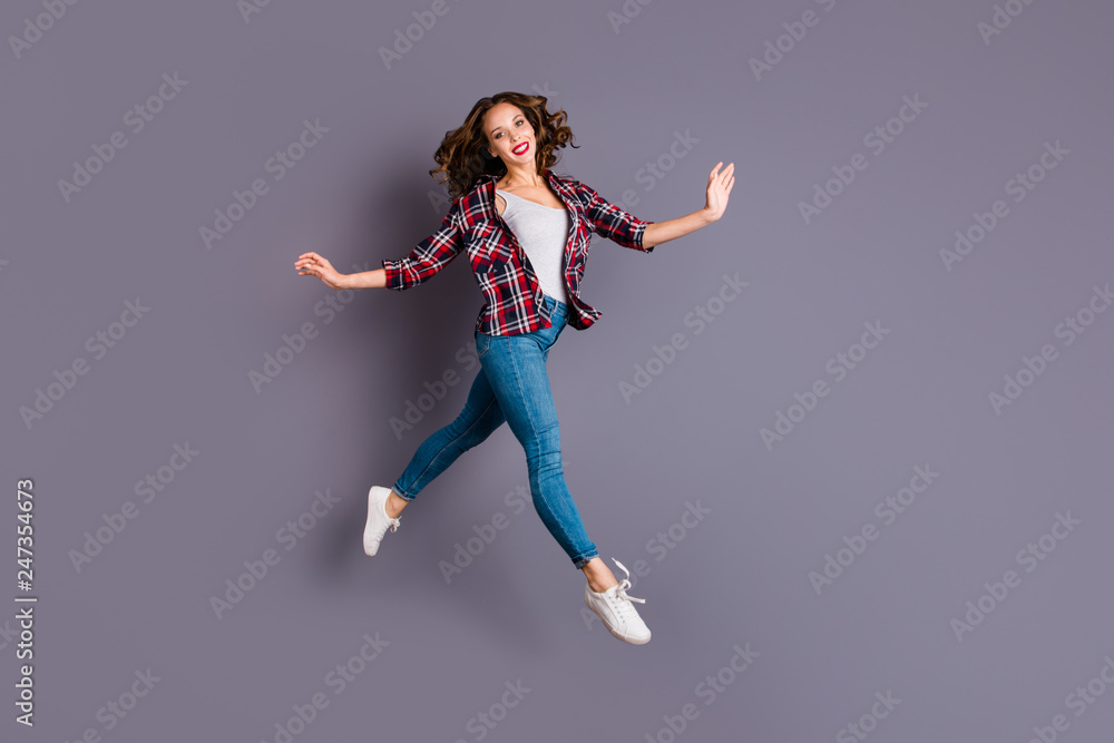 Full length size body view photo jumping high amazing attractive beautiful she her lady flight up in air not rushing pretty cute wearing casual jeans denim checkered plaid shirt grey background