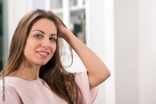 Woman looking at camera and touching hair