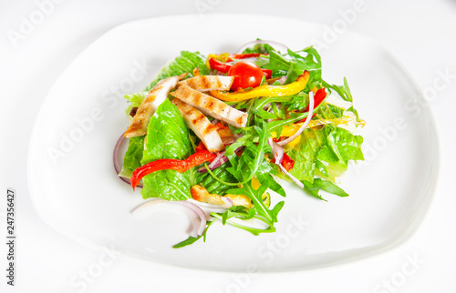 Delicious salad with meat, tomatoes and greenery on white