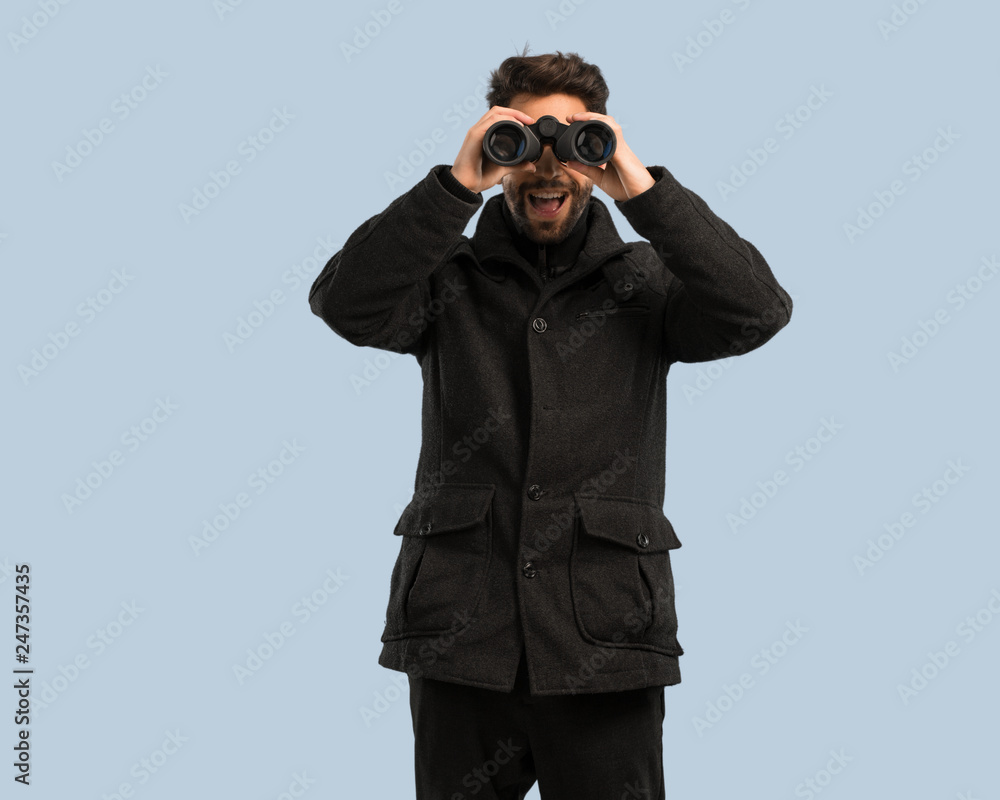 young man looking through the binoculars young man looking through the binoculars
