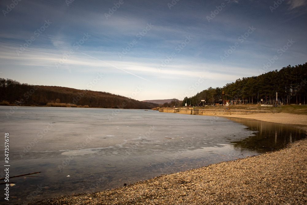 Beach by the frozen lake. Beautiful sunny winter day. Sumarice lake near the Kragujevac in Serbia. Beach by the frozen lake. Beautiful sunny winter day. Sumarice lake near the Kragujevac in Serbia.