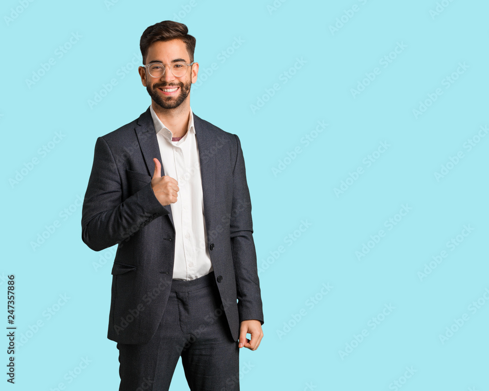 Young handsome business man smiling and raising thumb up Young handsome business man smiling and raising thumb up