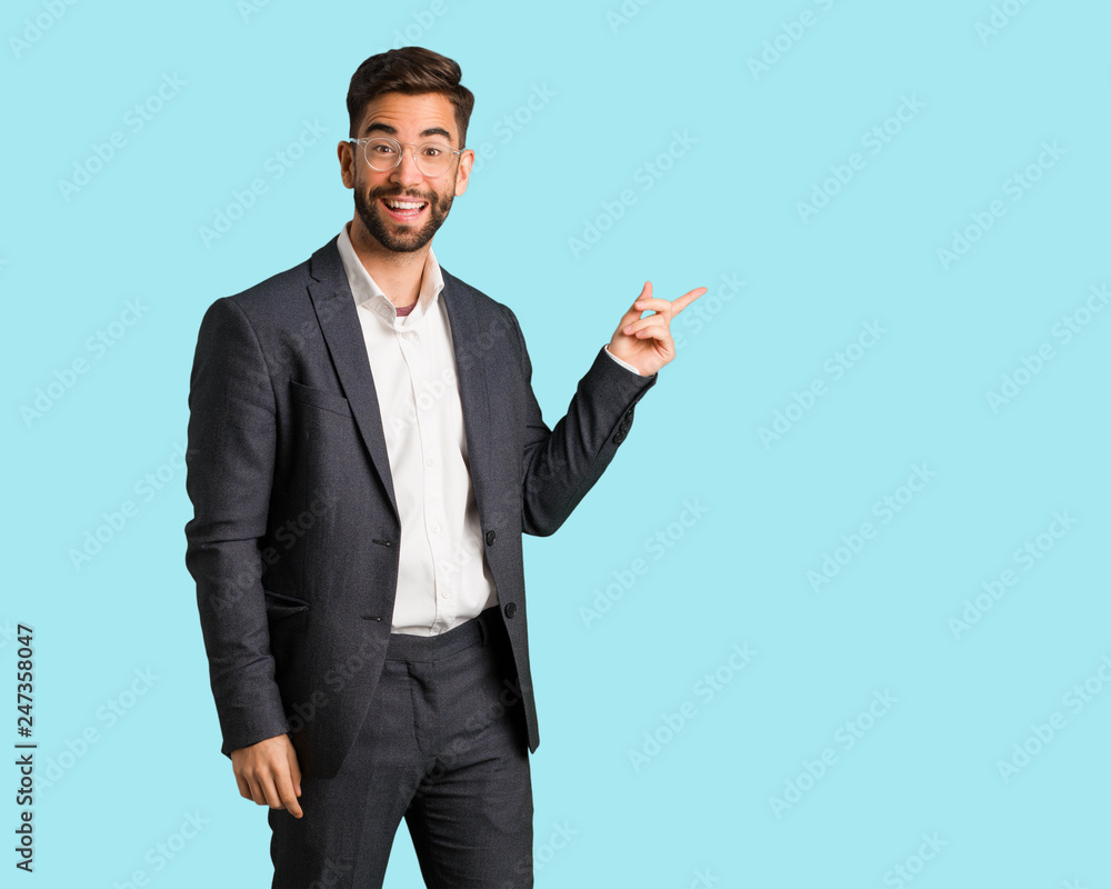 Young handsome business man pointing to the side with finger Young handsome business man pointing to the side with finger