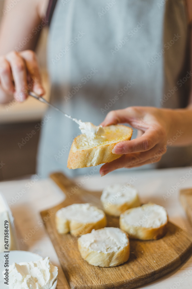 Closeup of housewife frying baguette pieces in a frying pan - making cold snacks - tapas and sandwiches