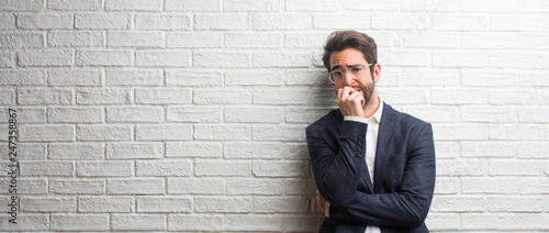 Fotografie Young friendly business man biting nails, nervous and very anxious and scared fo