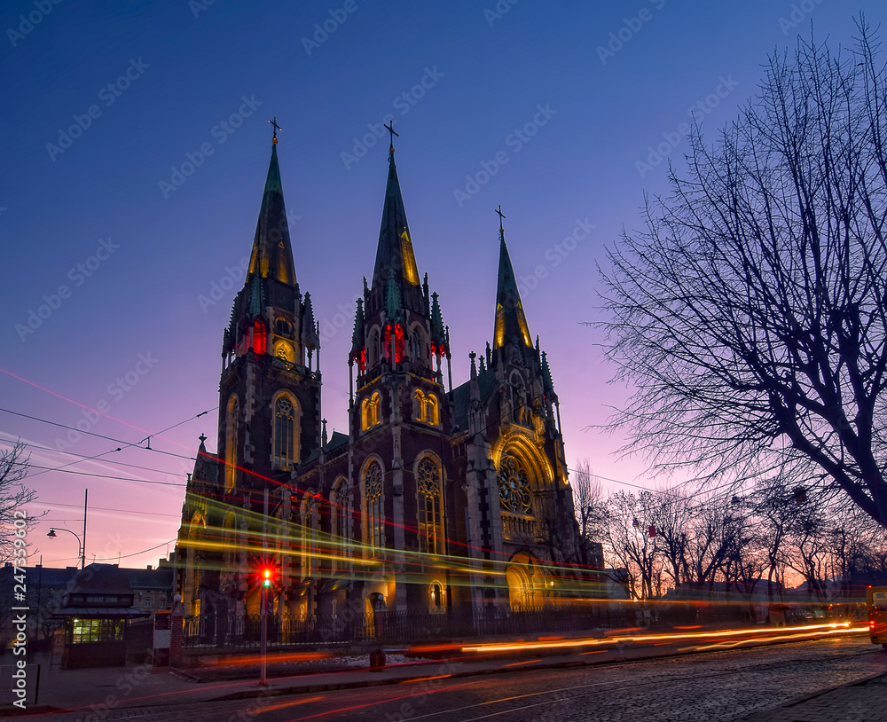 Fototapeta premium Nightscape of ancient gothic church with autotracks