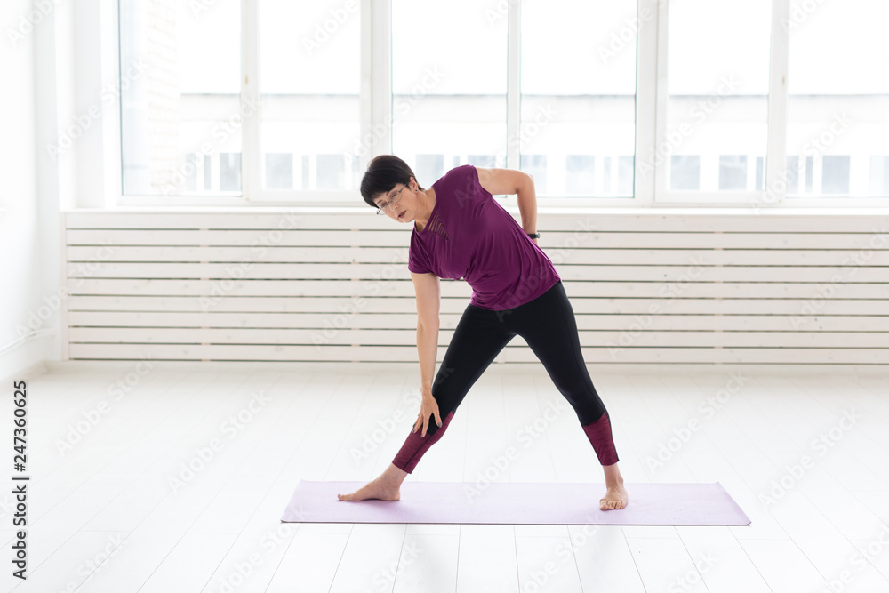 Healthy lifestyle, people and sport concept - Middle aged woman doing yoga Healthy lifestyle, people and sport concept - Middle aged woman doing yoga