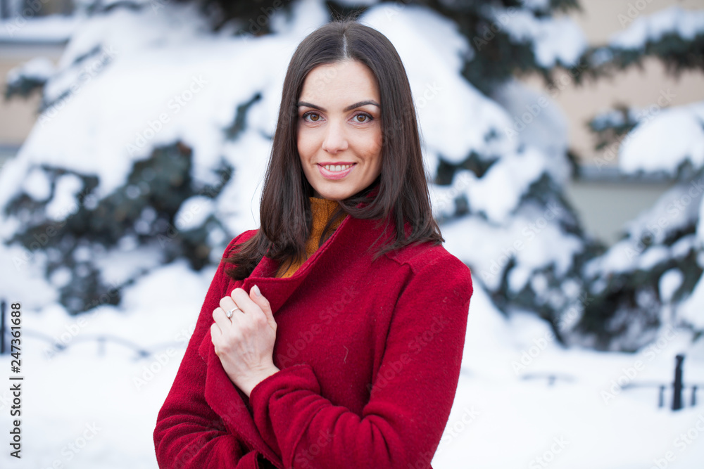 Young beautiful brunette woman in red coat posing on winter park Young beautiful brunette woman in red coat posing on winter park