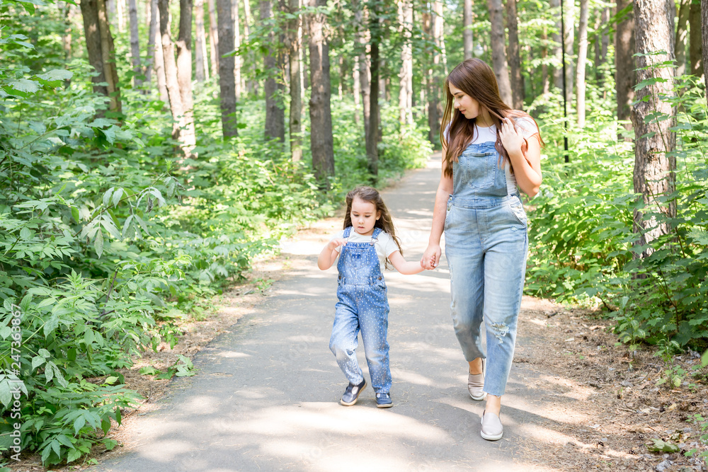 Family, nature and people concept - Mom and baby daughter spend time together on a walk in the green park Family, nature and people concept - Mom and baby daughter spend time together on a walk in the green park