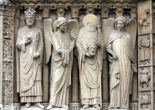 Paris, Notre-Dame cathedral, portal of the Virgin. From left to right: Emperor Constantine, an angel, Saint Denis holding his head, and another angel. © zatletic