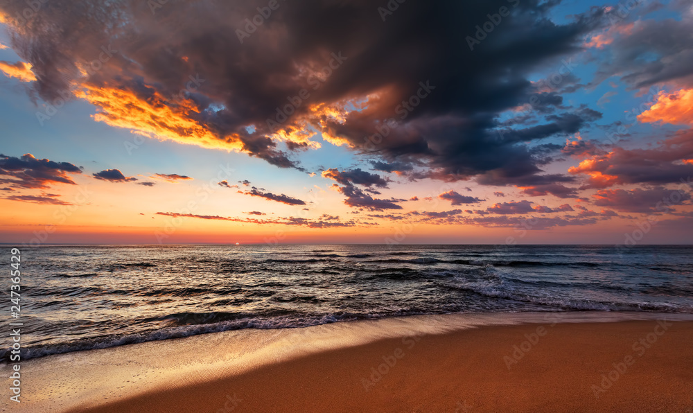 Sunset seascape with dramatic sky and colorful clouds.