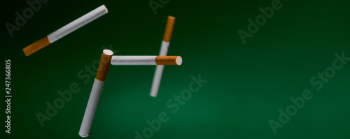 Cigarettes fall on a green background.