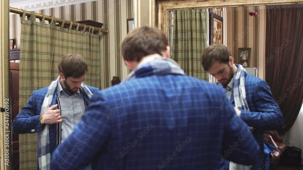 Young, handsome and successful businessman trying on a custom made stylish suit at tailors shop. Dressmaking and Tailoring establishment concept Young, handsome and successful businessman trying on a custom made stylish suit at tailors shop. Dressmaking and Tailoring establishment concept