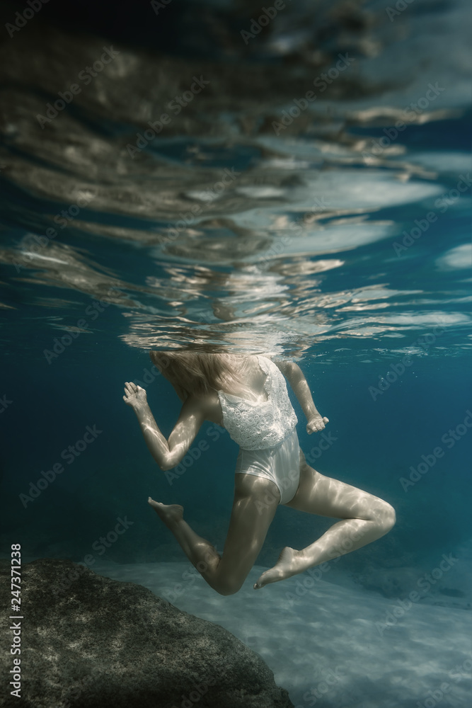 Woman in white under water in the sea