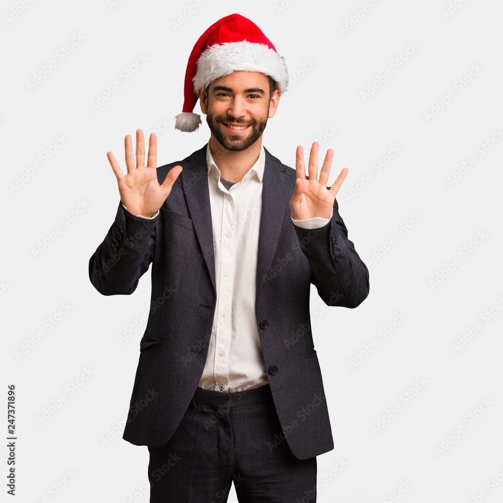 Young business man wearing santa hat showing number nine Young business man wearing santa hat showing number nine