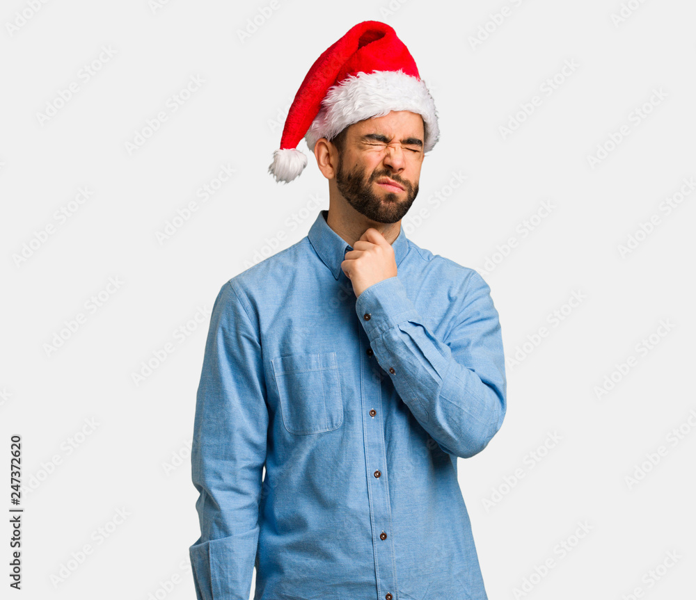 Young man wearing santa hat coughing, sick due a virus or infection Young man wearing santa hat coughing, sick due a virus or infection