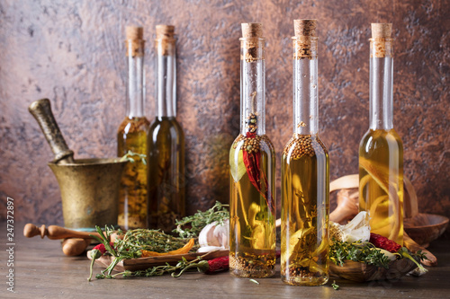 Fototapeta Naklejka Na Ścianę i Meble -  Bottles of olive oil with different spices and herbs.