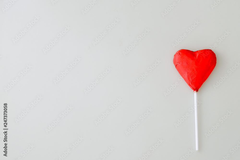 Heart shaped chocolate candiy with red wrappings on a white background