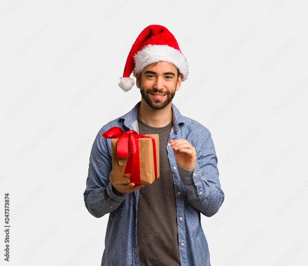 Young man wearing santa hat showing number six Young man wearing santa hat showing number six