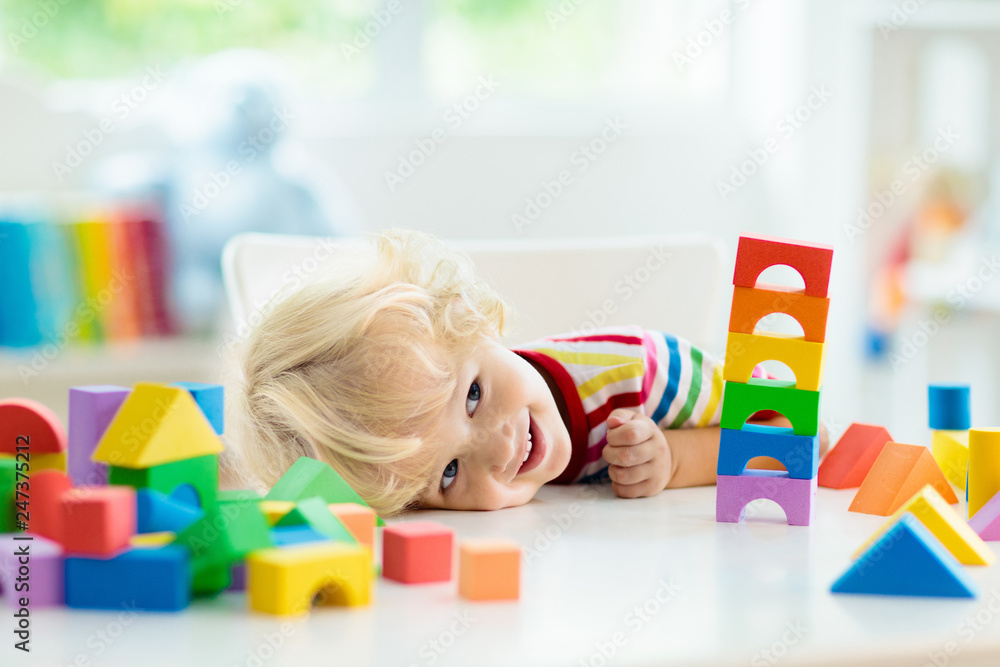 Kids toys. Child building tower of toy blocks. - obrazy, fototapety, plakaty 