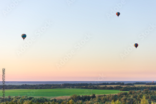 Flying in a balloon. Three objects in the air against a cloudless sky. Evening landscape.