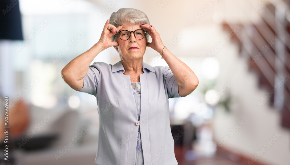 Beautiful senior woman man making a concentration gesture, looking straight ahead focused on a goal at home. Beautiful senior woman man making a concentration gesture, looking straight ahead focused on a goal at home.