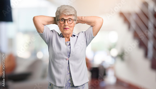 Fotografie Beautiful senior woman crazy and desperate, screaming out of control, funny lunatic expressing freedom and wild at home