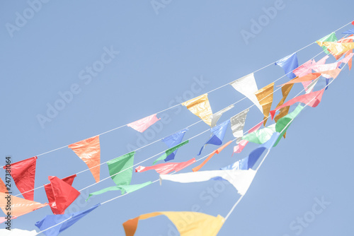 Colorful Party flags bunting hanging on blue sky for holiday decoration